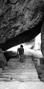 Rear view of people walking on rock