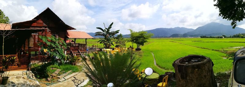 Panoramic view of field and houses against sky