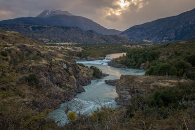 Scenic view of river amidst mountains against sky