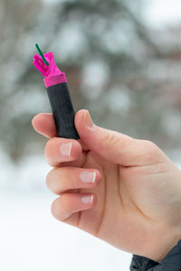 Close-up of hand holding toy against white background