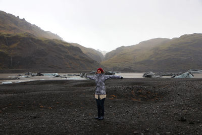 Man standing on shore against sky