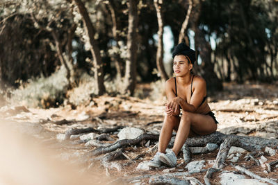 Young woman sitting in forest