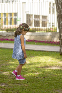 Full length of girl standing against plants in park