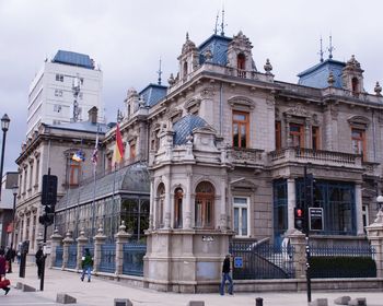 People on street against buildings in city