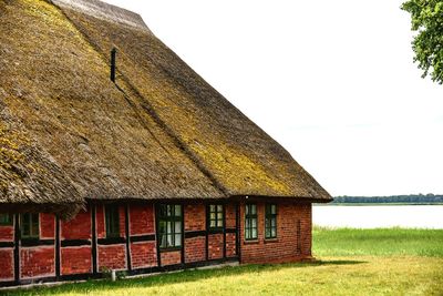 House on field against clear sky