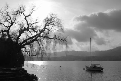 View of boats in calm lake against mountain range