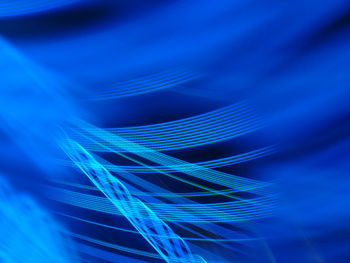 Close-up of light trails over blue background