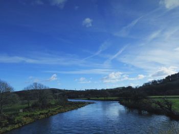 Scenic view of river against cloudy sky