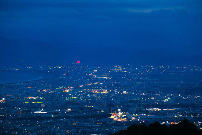 High angle view of city lit up at night