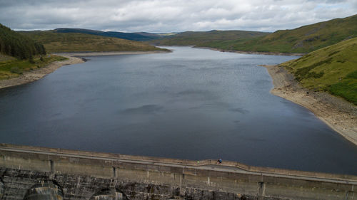 High angle view of river amidst mountains against sky