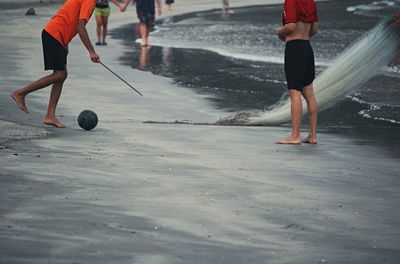 Rear view of man running on sand at beach