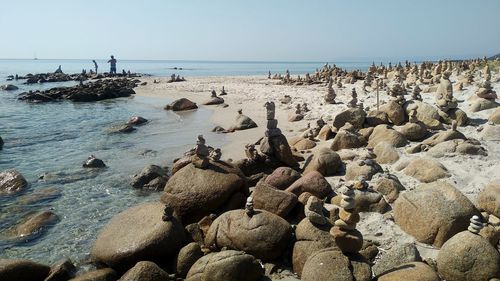 Rocks in sea against clear sky
