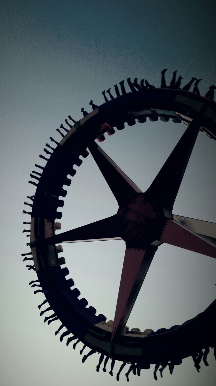 low angle view, metal, circle, silhouette, clear sky, close-up, sky, metallic, arts culture and entertainment, geometric shape, no people, part of, shape, day, outdoors, pattern, dusk, wheel, built structure, directly below