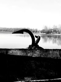 Close-up of railing by lake against clear sky