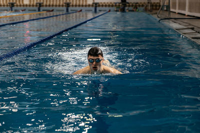 Portrait of shirtless man swimming in pool