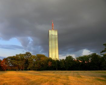 Tower on field against cloudy sky