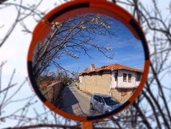 Reflection of house and car in road mirror