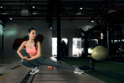 Full length of young woman sitting on floor