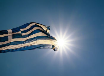 Low angle view of flag against blue sky
