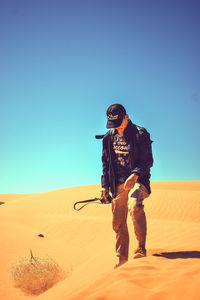 Full length of man standing in desert against clear sky