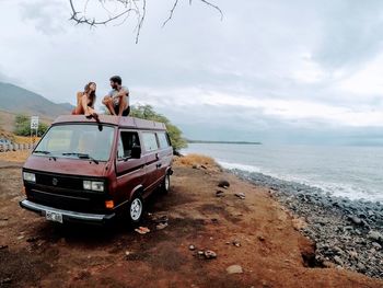 People on beach by sea against sky