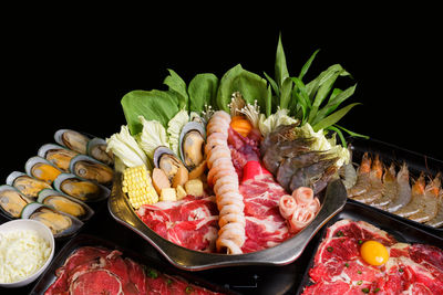 Close-up of fruits in plate against black background