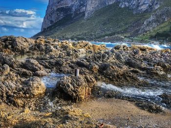 Scenic view of rocky beach against sky