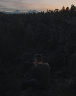 Rear view of man smoking cigarette at mountain