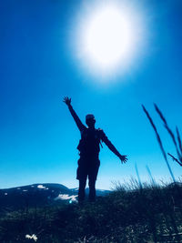 Full length of man standing on mountain against blue sky