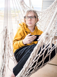 Portrait of tween in hammock listening to music