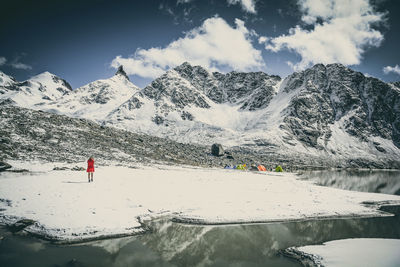 Rear view of woman against snowcapped mountains