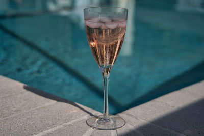 Close-up of wine champagne glass on pool