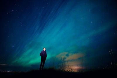 Full length of woman standing on field against sky at night