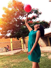 Young woman standing with balloons in park