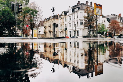 Reflection of buildings in puddle on street