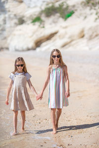 Happy friends standing at beach