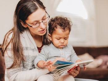 Mother and son reading book at home