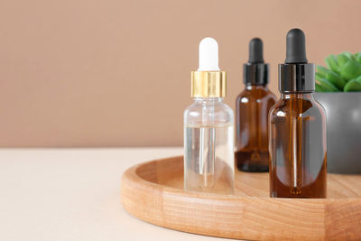 Glass bottles on wooden plate. natural spa design. mineral oil cosmetics. earth tones. mock-up.