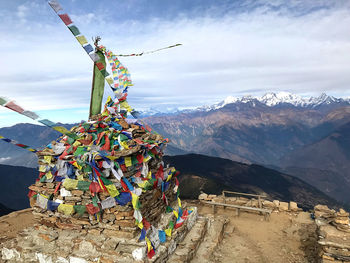 Multi colored flags hanging on mountain against sky