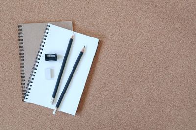 High angle view of plant and pencil on book