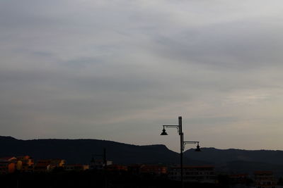 Low angle view of street light and buildings against sky