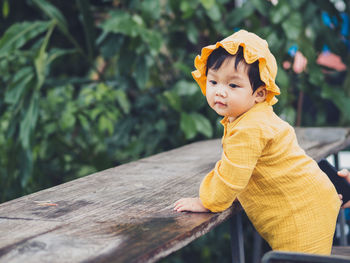 Portrait of young woman standing against plants