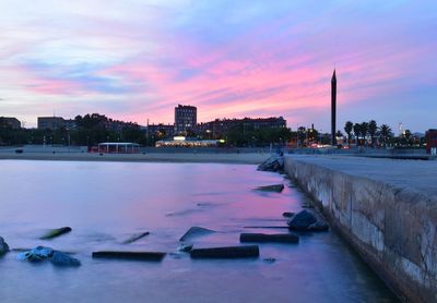 View of city at waterfront during sunset