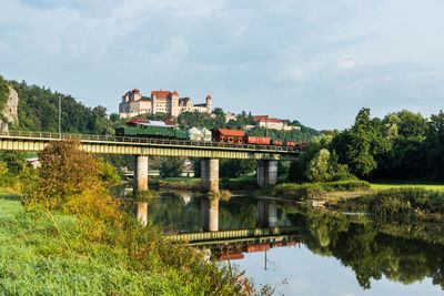 Arch bridge over river against sky