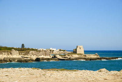 Fort at beach against clear blue sky