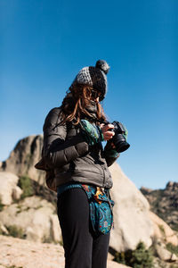 Full length of woman standing against clear blue sky