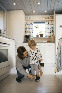 Rear view of mother and son on floor