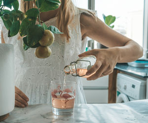 Midsection of woman having food at home