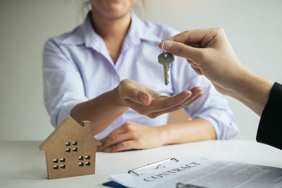 Midsection of woman holding paper with text on table