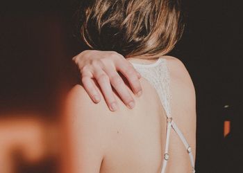 Rear view of woman in lingerie sitting at home